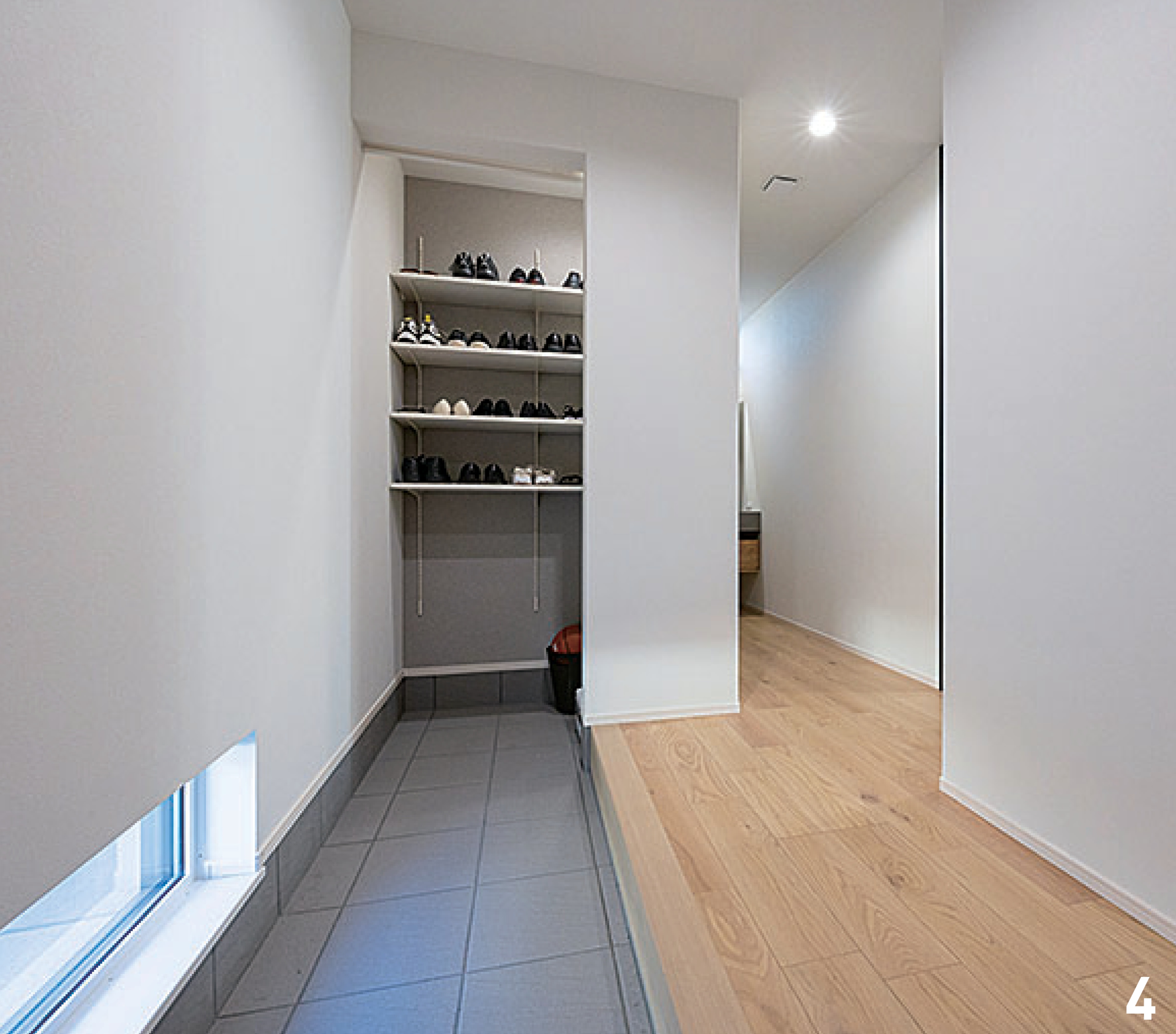 アイ工務店 阪和支店｜シンプルでモダンな玄関ホール。明るい照明と足元の窓が空間を広々と見せ、収納棚が実用性を高めている。