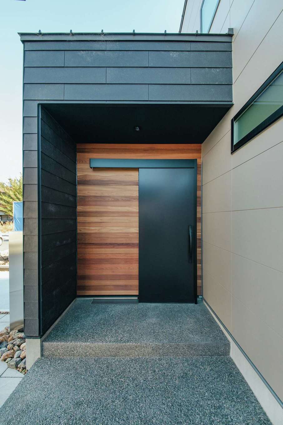  ソラマド浜松【デザイン住宅、子育て、間取り】家の顔であるファサードは、ラップサイディングとレッドシダーをバランス良く融合させて高級感を出した。玄関ホールまで連続する洗い出しのポーチにも趣を感じる