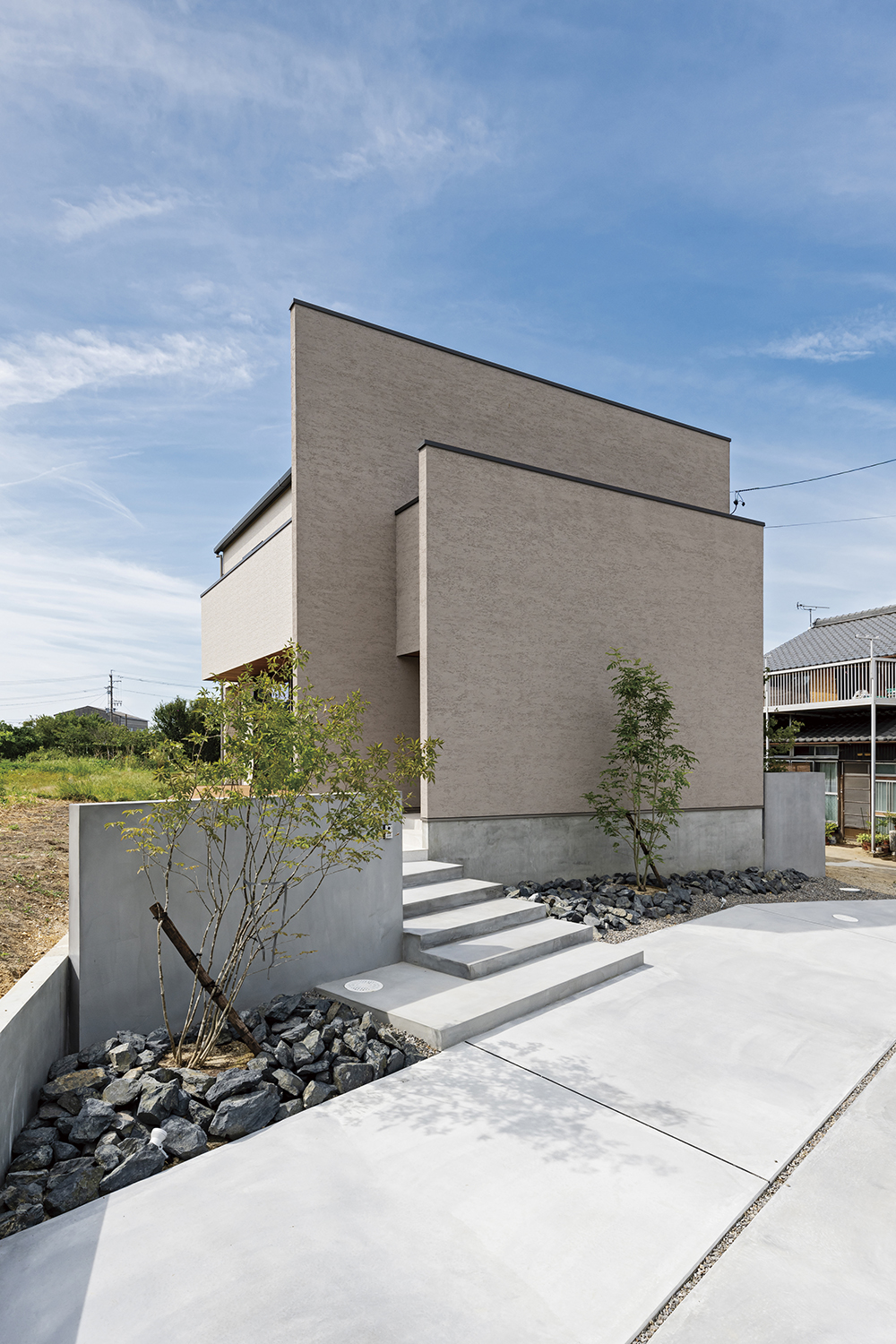 アールギャラリー（アールプランナー）【デザイン住宅、子育て、建築家】塗り壁の外壁と植栽の緑とのコントラストが素敵な外観。夜になると間接照明の演出でより美しく映るそう