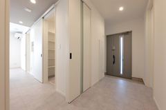 明るく広々とした玄関ホール。シンプルなデザインが際立ち、清潔感あふれるスペースとなっている。パネルドアが収納スペースを隠し、すっきりとした印象を与える。