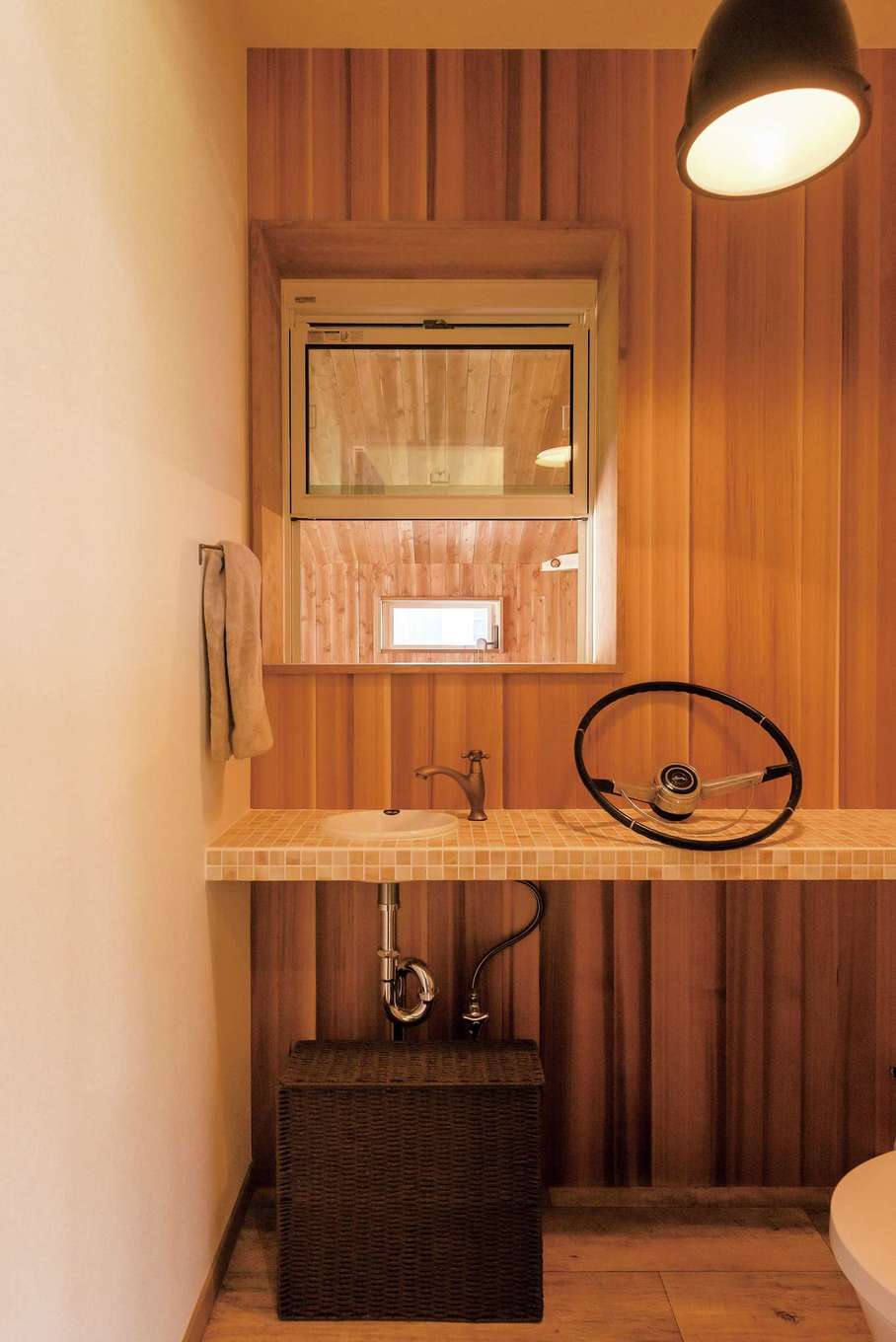 富士ホームズデザイン｜レッドシダーの壁にタイルのカウンターを造作したトイレ。窓からはガレージが見える