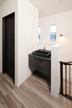 シンプルでモダンな洗面スペース。コンパクトながら、無駄のないデザインが効率的で便利な空間を実現している。