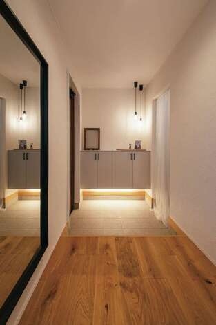 以前の玄関が狭かったため、広々とした玄関を希望。収納下部に設えられた間接照明のあたたかな光が帰宅を迎える。入って正面にはシューズクロークが用意され、そのままパントリーへと続く