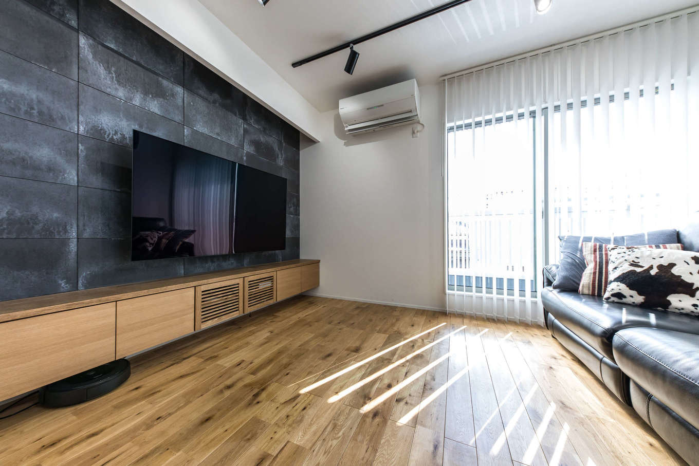 建築システム（狭小住宅専門店）【狭小住宅、間取り、屋上バルコニー】黒いモルタル調の壁はシックなカフェのイメージを再現したもの。昼間は子どもたちが遊ぶリビングも、夜は間接照明でグッとムーディな空間に