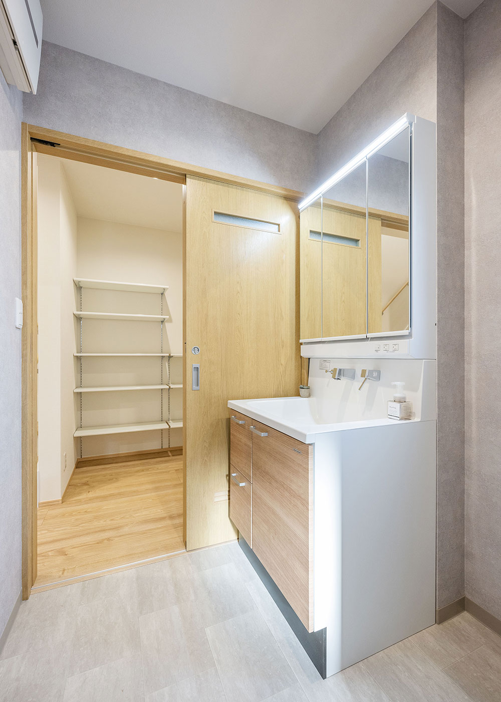 irohaco（アヴァンス）【デザイン住宅、収納力、和風】洗濯物を洗って、乾かして、そのままファミリークローゼットに収納する「神動線」が共働き夫婦の家事時間を短縮し、お支度の混雑も解消。無機質なコンクリート調のクロスを貼り、ナチュラルなLDKと変化をつけた