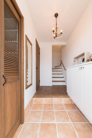 シューズクロークを備えた子世帯の玄関。奥の扉で親世帯と気軽に行き来できるようになっている。階段は踏面を広くするよう要望 。荷物の上げ下げもしやすくて正解だった