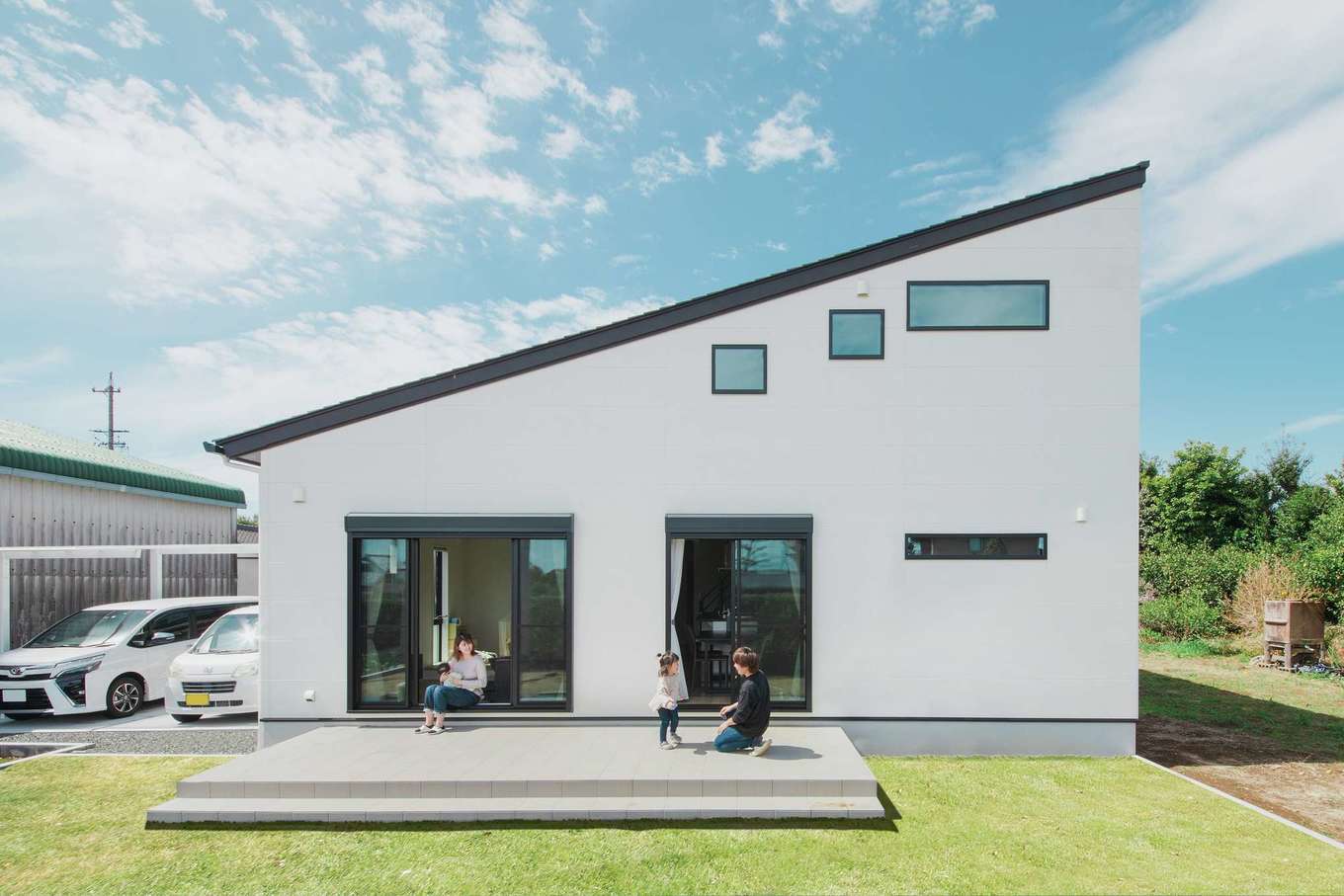 Yamaguchi Design 掛川店（アイフルホーム 掛川店）【デザイン住宅、子育て、間取り】片流れの大屋根がシャープな白い外観は、平屋のように見えて実は二階建て。１階だけで生活できるようになっており、二階部分には子ども部屋が２部屋と小屋裏収納を配置。庭は人工芝にして、広いタイルデッキを設けた。バーベキューもしやすそう！