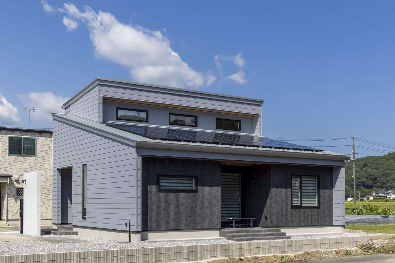 フィアスホーム 掛川店【デザイン住宅、省エネ、間取り】平屋よりもコストパフォーマンスが良いことから「平屋風の二階建て」に。軒を伸ばすことで夏の強烈な太陽光を遮り、太陽高度の低い冬は室内の奥まで光を届けるパッシブデザインを採用。9kWのソーラーパネルを搭載し、昼間に発電した電力で暮らしている