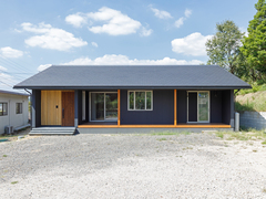 シンプルでモダンな平屋の外観。落ち着いた色合いの外壁に、広い敷地が開放感を演出している。