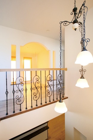 2階ホール。優美なデザインの手すりと照明が南仏の雰囲気を一層盛り上げる。奥に見えるファ ミリールームなど至るところにアーチ型の下り壁も採用