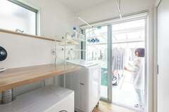 ランドリールームの外側が物干しスペース。乾燥機の上部に作業台も設置し、スムーズな動線で家事をこなせる