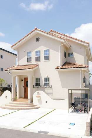 オレンジの瓦にクリーム色の壁、かわいい玄関ポーチ…理想通りの南欧風の家が完成。継ぎ目のないサイディングはメンテナンスが必要なく、見た目もすっきり