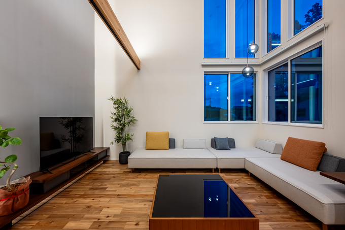 大きな窓からの自然光が魅力的なリビングスペース。シンプルなデザインと落ち着いたカラーの家具が、リラックスできる空間を演出している。