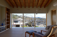 無垢材と珪藻土に包まれたリビングは高級旅館のようにくつろぐことができる。東側に面した窓越しに広がる自然の景色は額縁で切り取られた絵画のよう。天井の格子がアクセントに