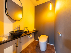 温かな照明で落ち着くトイレ。手洗器やプチ盆栽が和モダンな雰囲気です。