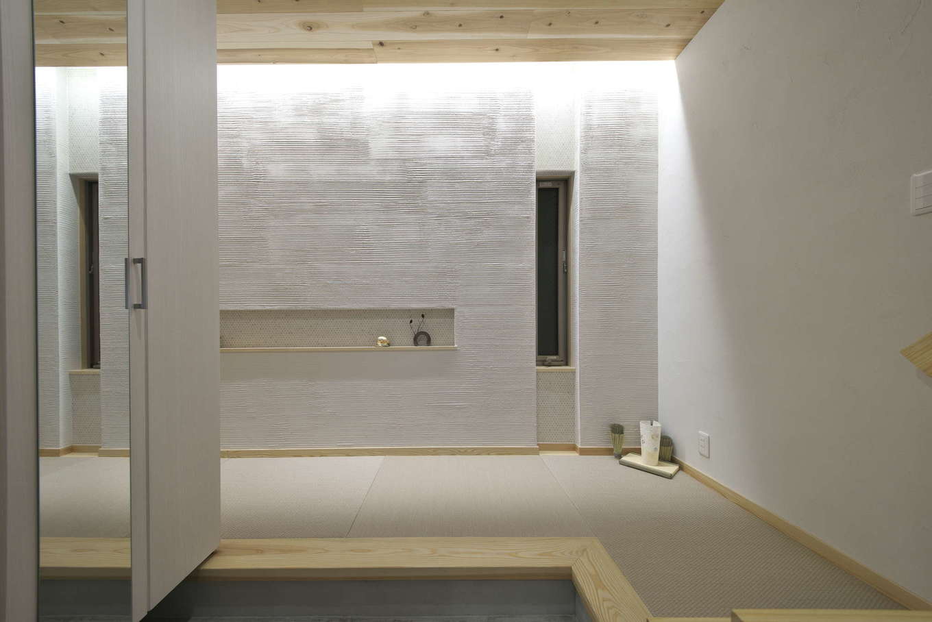あすなろ設計事務所【自然素材、狭小住宅、ガレージ】玄関には強度のある和紙畳を使用。珪藻土の壁は、面ごとに塗り方を変えることで表情豊かに