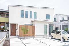 シンプルな白の外観に目隠しフェンスとシマトネリコがアクセント