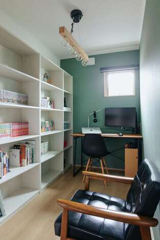 2階に用意されたご主人の書斎は、撮影した家族の写真の編集や読書タイムに。グリーンのクロスで落ち着く空間に仕上がった。大きな本棚も要望