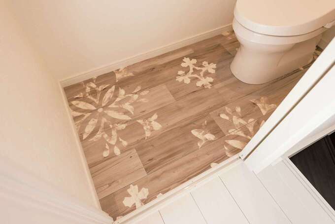 トイレの床でも、“サーファーズハウス”を表現。ステンシル調のボタニカルモチーフのクロスが個性的