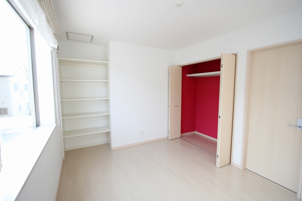 丸昇彦坂建設【デザイン住宅、子育て、間取り】5段の可動棚とクローゼットも備え、収納には困らない洋室。クローゼット内のクロスがアクセントになっている