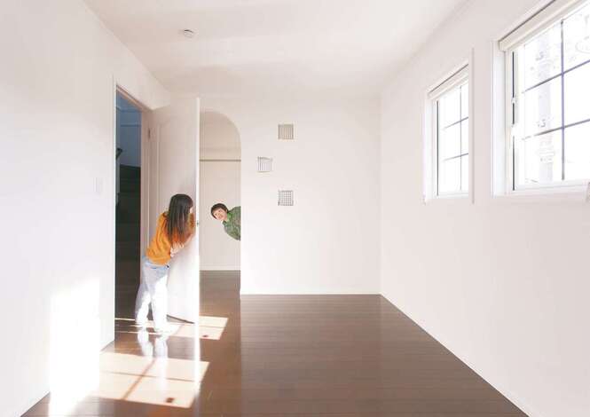 格子窓とアーチの開口部が洋館テイストでかわいい寝室。アーチの向こうはウォークインクローゼット