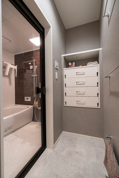 シンプルでモダンな脱衣スペース。十分な収納があり整理整頓しやすく、バスマット用のバーも付いているので使い勝手が良い空間。