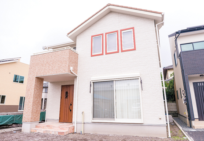 外観は南欧風に。ポーチの石材やバルコニー部分のタイルがリゾート感を演出している