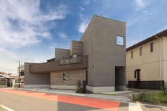 変形地に建てられたと思わせない現代的なデザインを持つ住宅の外観。シンプルながら重厚感があり、エレガントな印象を与えるデザイン