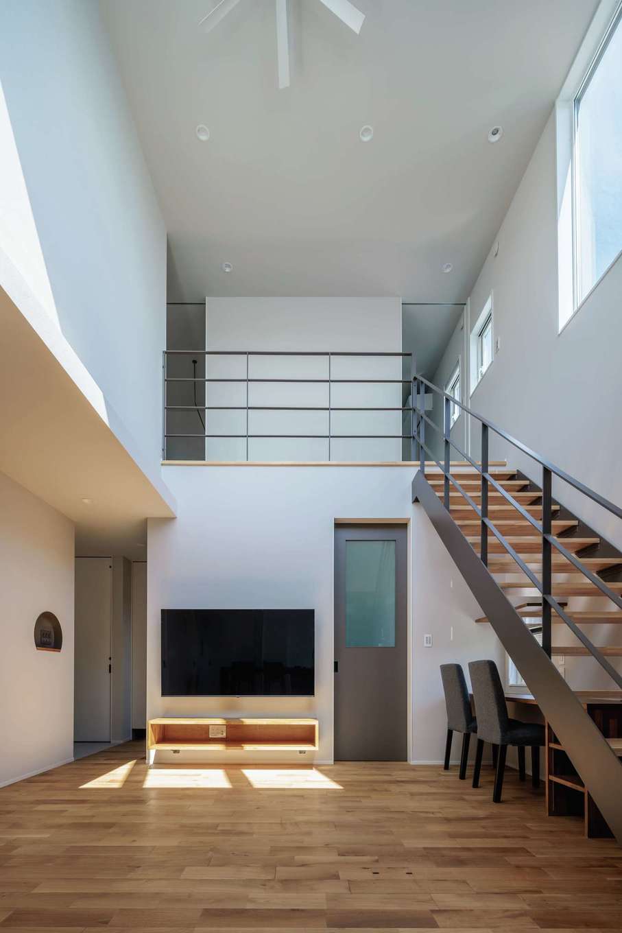 tact design firm【デザイン住宅、子育て、間取り】キッチンから見えるリビングの景色。吹抜けを通して2階の様子もわかるので安心。常に見える場所につくったニッチは四角ではなく半月形にして柔らかいイメージに