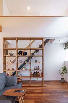 設計士の提案を採用し、階段に沿うように造作の棚が設えられた。空間を穏やかに分割しながら、本やインテリアによってK夫妻らしさや季節感が添えられていく