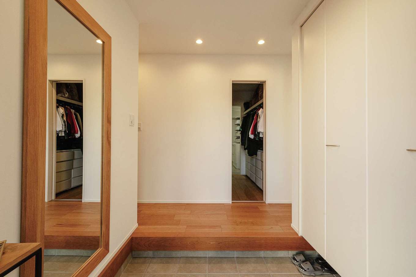 HAPPY HOUSE（山田工務店）【デザイン住宅、間取り、スキップフロア】全身鏡を採用したことで、より広く感じられる玄関。靴を脱いでウォークスルークローゼット、洗面脱衣室、浴室、キッチンへとつながる回遊動線を実現した