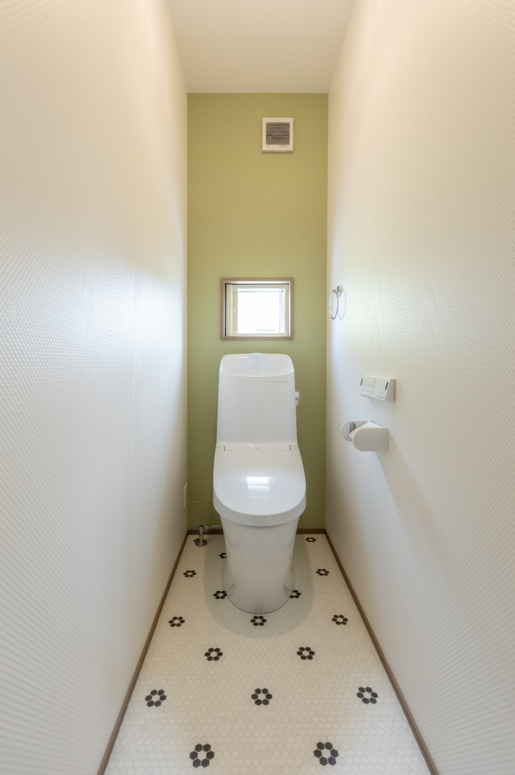 ユースタイルハウス　上村建設｜コンパクトながら明るい雰囲気のトイレ空間。
白を基調とした清潔感のあるデザインでまとめられている。
床の花柄タイルが可愛らしい印象を与える。