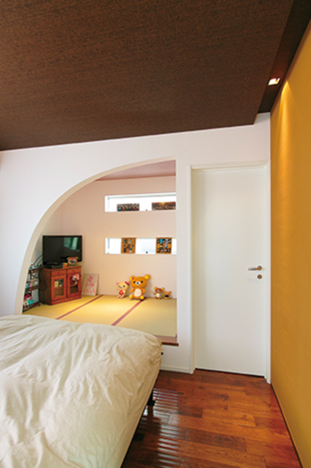 主寝室内の畳コーナーは夫婦の和みの空間。設計士が提案したアーチのラインがやさしさを演出。右側の白い扉を 開けるとご主人の書斎につながる
