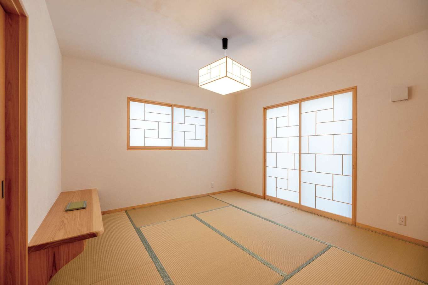 藤田工務店【和風、自然素材、平屋】夫婦の寝室は8.5畳の和室に。障子は気に入った照明の傘のデザインに合わせた造作。天井は漆喰の塗り壁。コテ跡が目立たない仕上げで、寝室にふさわしいシンプルな空間に