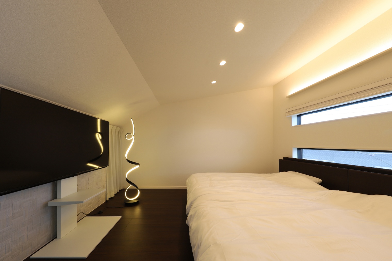 アイダ設計　｜モダンで落ち着いた雰囲気の寝室。シンプルな照明が心地良い空間を演出している。アクセントとなる黒い家具が洗練された印象を与える。