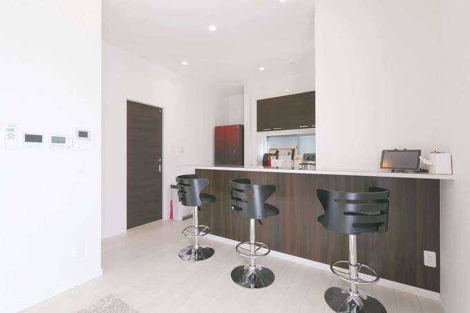 夫婦でお酒を楽しむために、キッチンをバーカウンターっぽくコーディネート。黒いスツールもおしゃれ