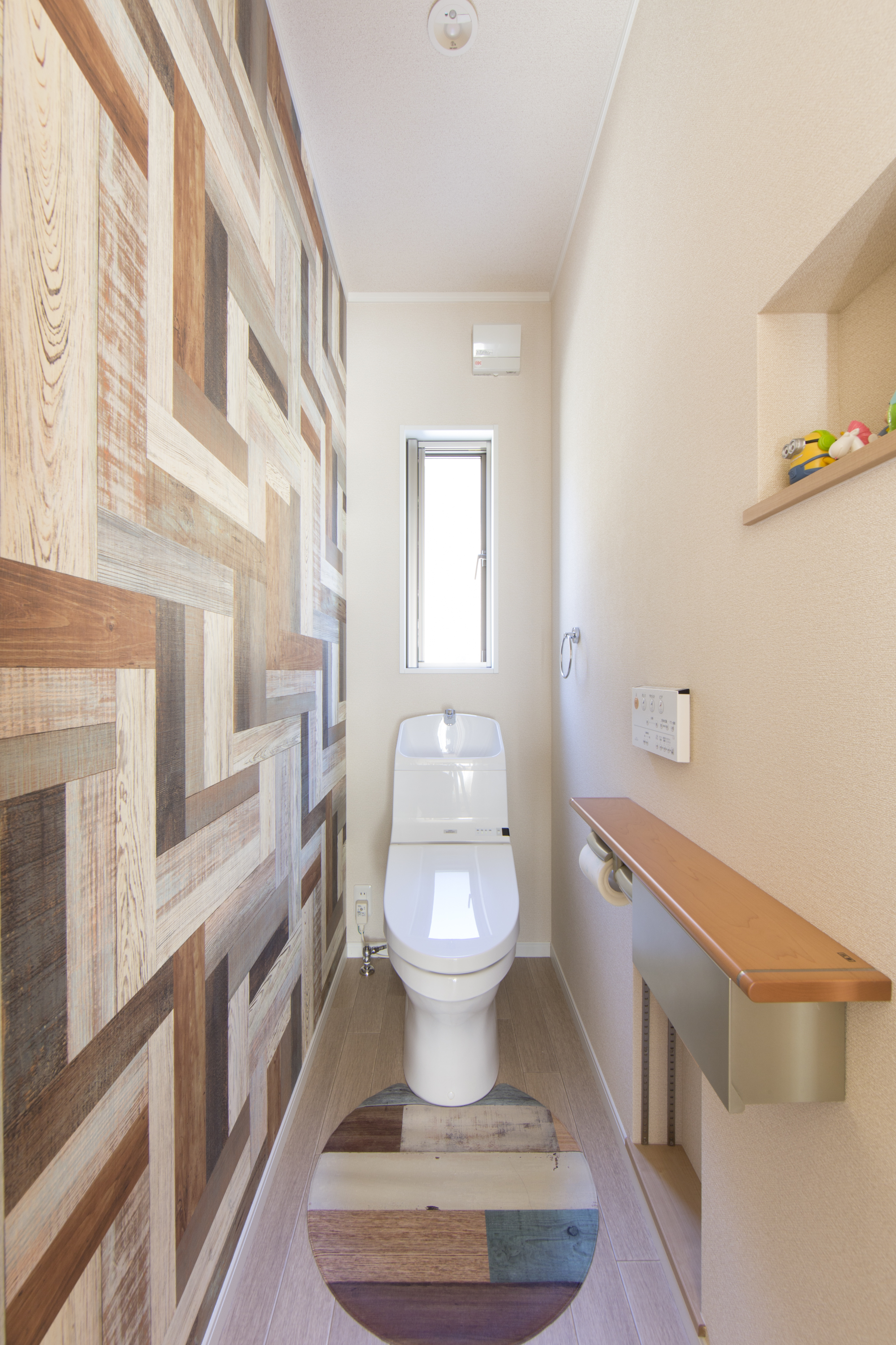 エスホーム｜木目調のアクセントウォールが特徴的な２階のトイレ。大胆なクロスでも２階のトイレなら遊び心を取り入れられる。