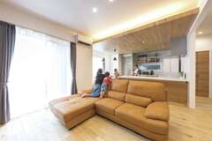 ナラの無垢材を使ったフローリングの肌触りが心地良いリビング。キッチン〜ダイニングを回遊できる造りで、スムーズな家事動線を確保している