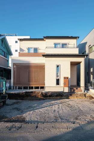 デッキの格子が目を引く外観。玄関は通りから直接内部が見えないように配慮。太陽光を搭載し、ZEHを実現する