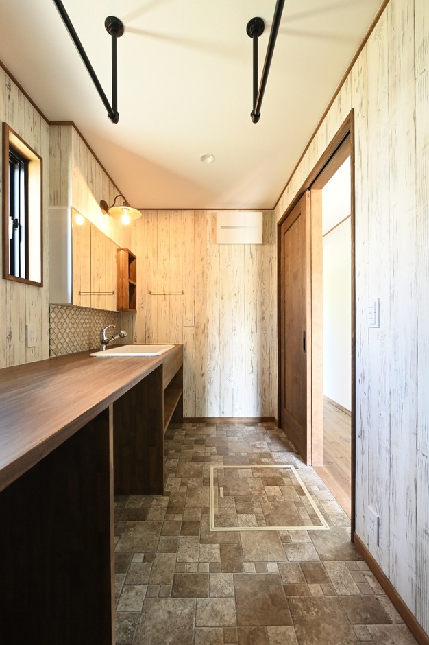 デザイン製のある壁面とウッド調の床が印象的な脱衣スペース。ゆったりとしたレイアウトで使いやすい。