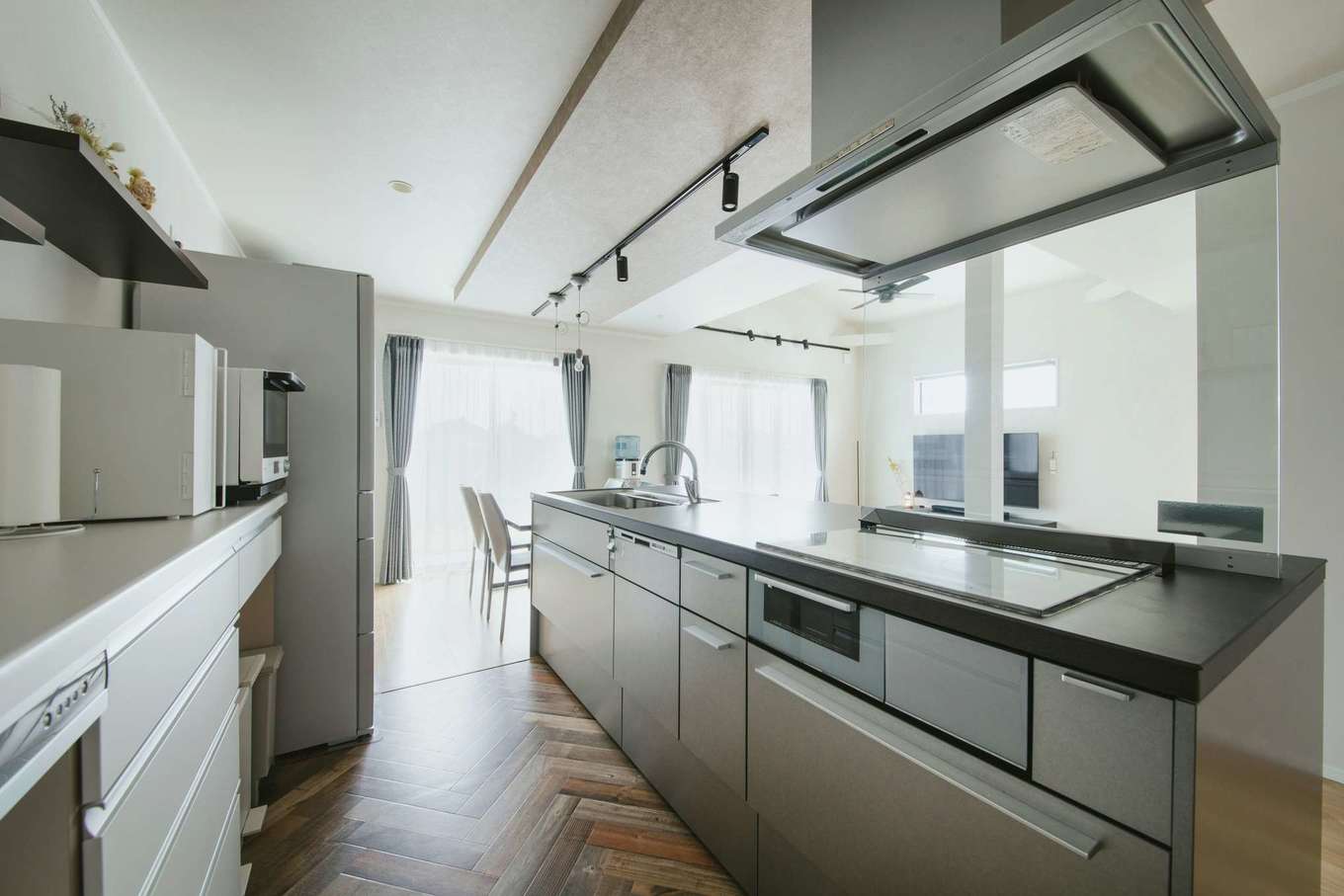 Yamaguchi Design 掛川店（アイフルホーム 掛川店）【デザイン住宅、子育て、間取り】アイランドキッチンの下がり天井も夫妻のこだわり。キッチンと背面の収納はどちらも引き出しタイプなので、出し入れがしやすいようにワークスペースを広めに取った