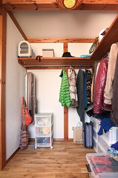 寝室のウォークインクローゼット。Ｌ字型にハンガーと棚を設け、どこに何があるかひと目でわかるので便利。各所に機能的な収納が設けられているのもこの家の魅力のひとつ