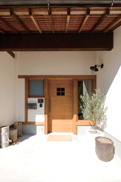 玄関扉は既製品ではなく、施主さんとデザインを練り上げて造作した木の引き戸。昔のままの軒下が化学反応を起こし、新たな魅力が生まれた