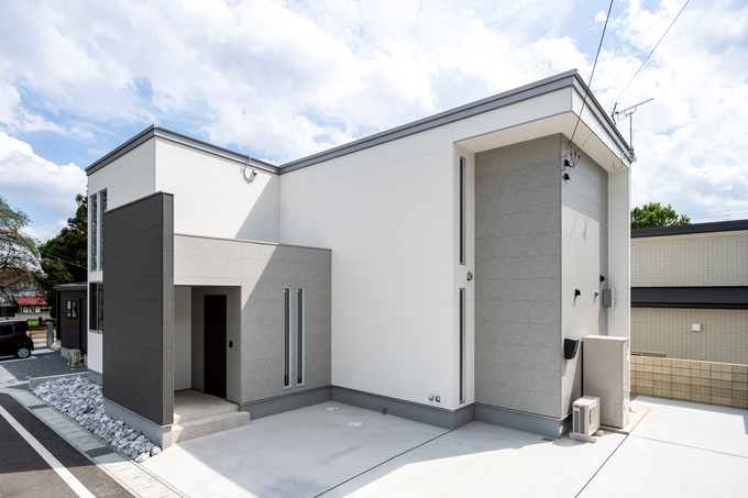 シンプルでモダンなデザインの住宅外観。直線的なラインと白を基調としたカラーが、洗練された印象を与えている。