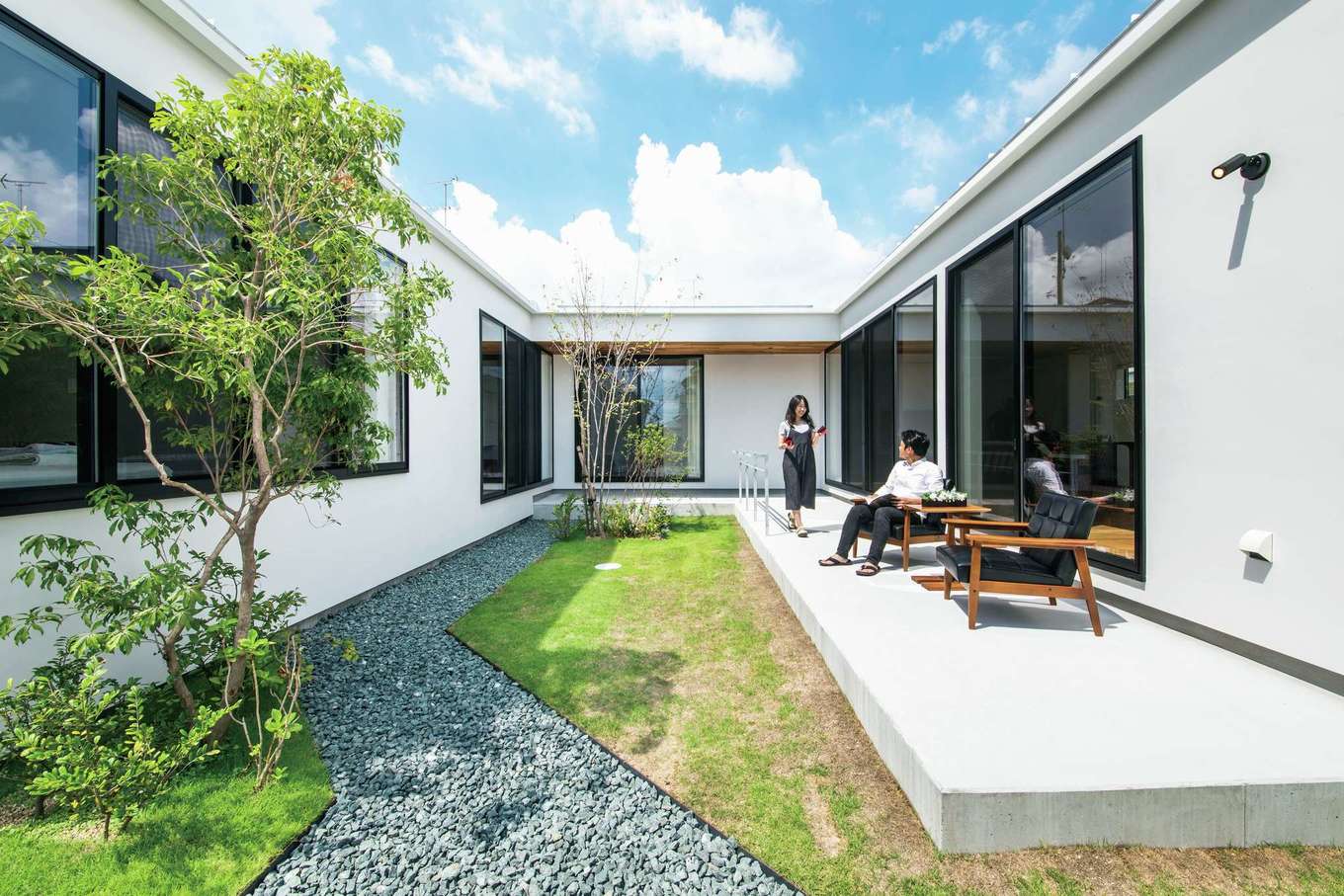 インフィルプラス【デザイン住宅、高級住宅、平屋】「コの字」型の建物に囲まれた中庭は、家族だけのプライベート空間。建物と庭が一体化し、アウトドアリビングのように開放的にくつろげる。写真の正面は玄関。LDKと寝室・子ども部屋が中庭をはさんで向かい合わせに配置されているため、離れていても家族の様子がよくわかる。「SE構法」により、これだけの大開口でも耐震等級3を確保できた
