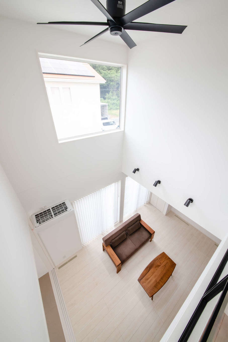 子育て安心住宅＆デザインラボ【デザイン住宅、子育て、間取り】2階から眺めたリビング。吹き抜けの高窓が室内全体に明るさをもたらし、開放感でいっぱい。4人の子どもたちものびのびと過ごせるようになり、笑顔がいっそう増えた