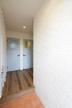 玄関は壁の一部にエコカラットを採用。凸凹とした独特な素材の風合いが印象的。調湿・消臭効果を備えているため、雨などでジメジメとした日でも外から帰ってくるとさらりとした空気に包まれる