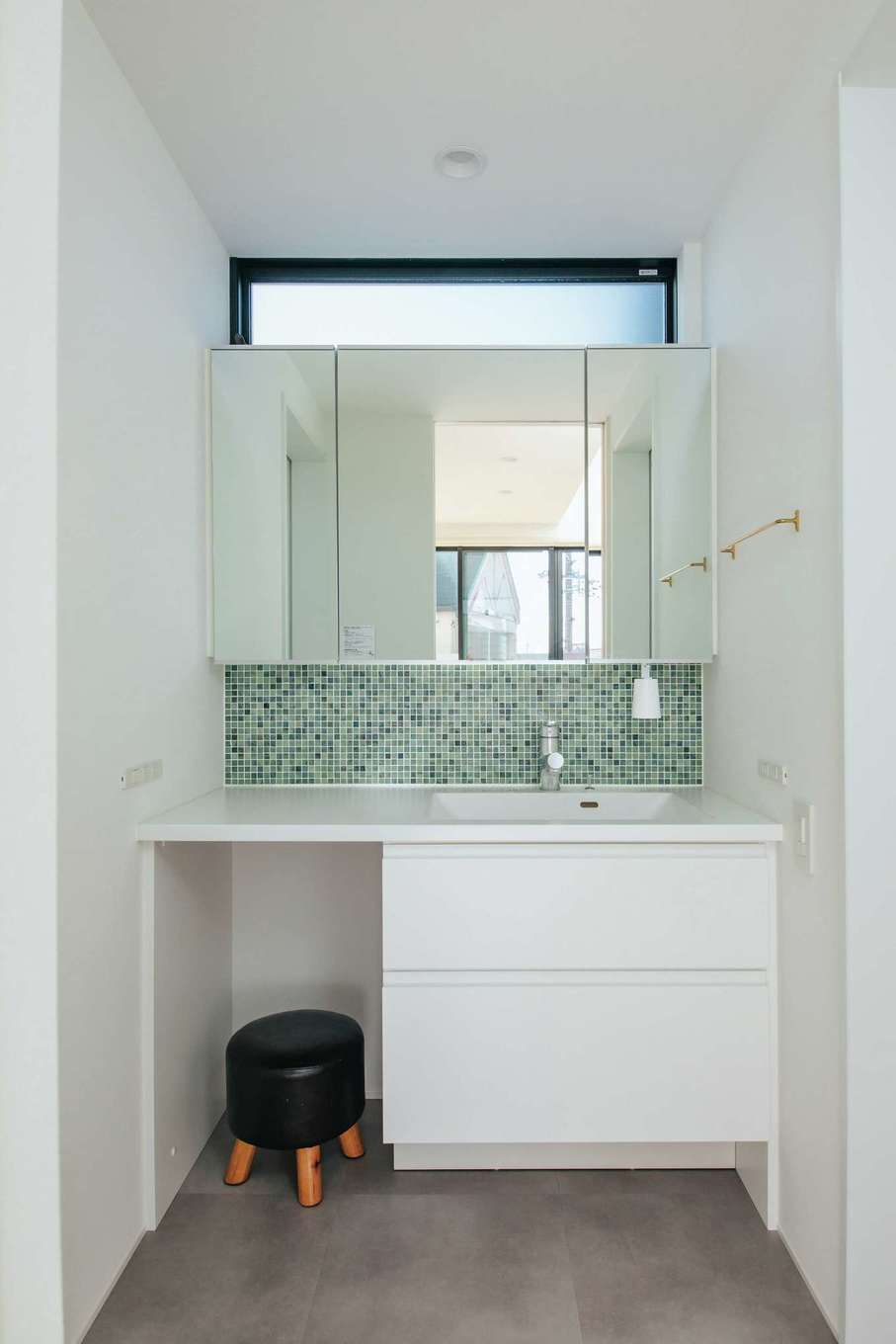  ソラマド浜松【デザイン住宅、子育て、間取り】奥さまこだわり造作洗面台はメイクアップもできる。かわいいタイルがアクセントに。ハイサイドライトからの柔らかな光が北面でも十分な明るさを届ける。脱衣室と分離させたことで、誰かが入浴中でもいつでも歯磨きや洗面ができる