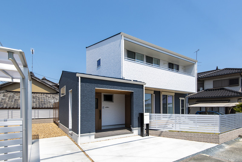 トキワハウス デザイン アンド ビルド（常盤工業）｜白と青のコントラストが美しい、モダンな二階建て住宅の外観。周囲と調和しつつ、モノトーンのフェンスが洗練された印象を与える。