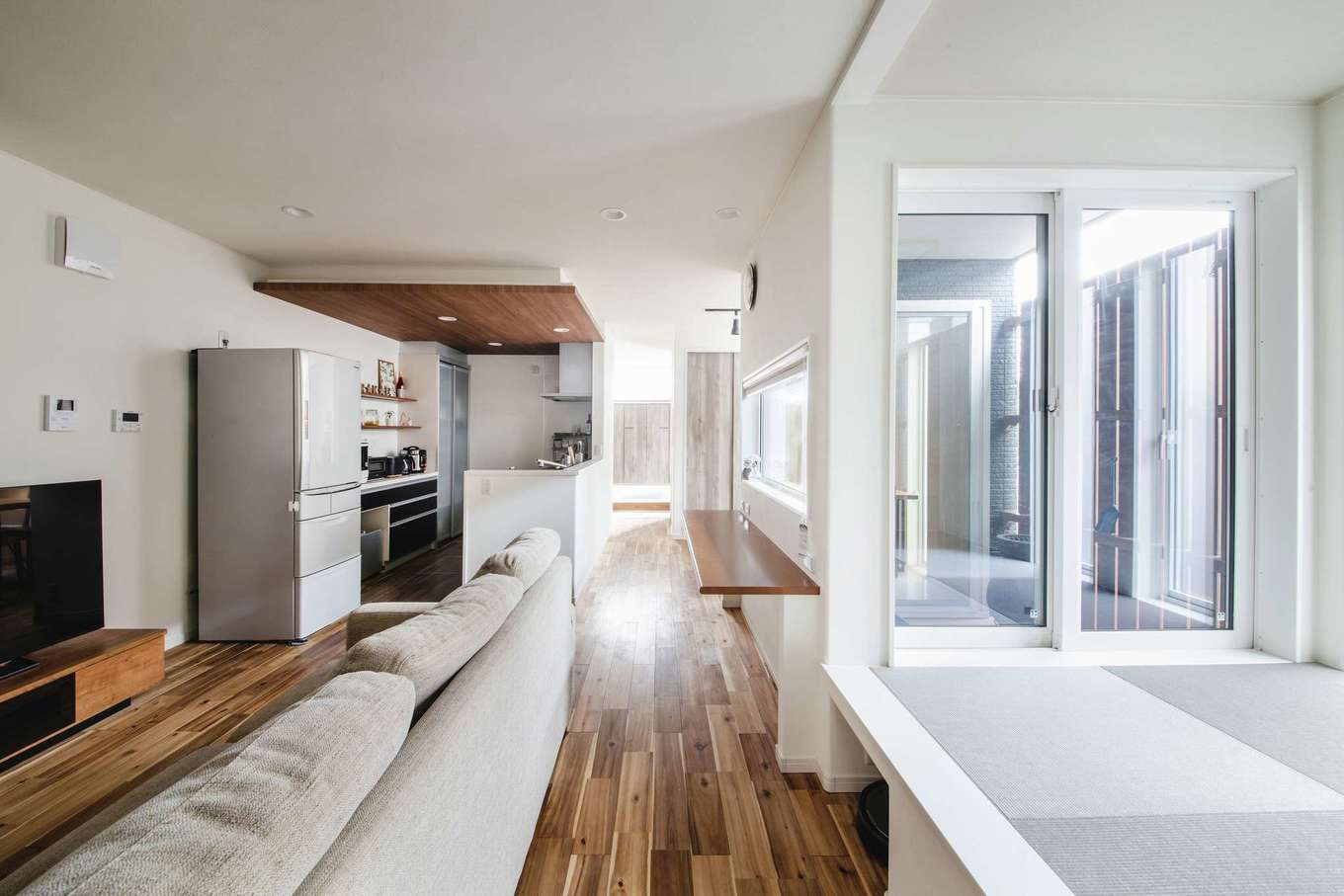 子育て安心住宅 Design Craft Office【デザイン住宅、子育て、狭小住宅】無垢の床が素足に温かいリビング。18.2畳の空間に、夫妻の希望した要素をすべて組み込んでいる。市街地の細長い敷地でありながら、明るさも十分に確保された